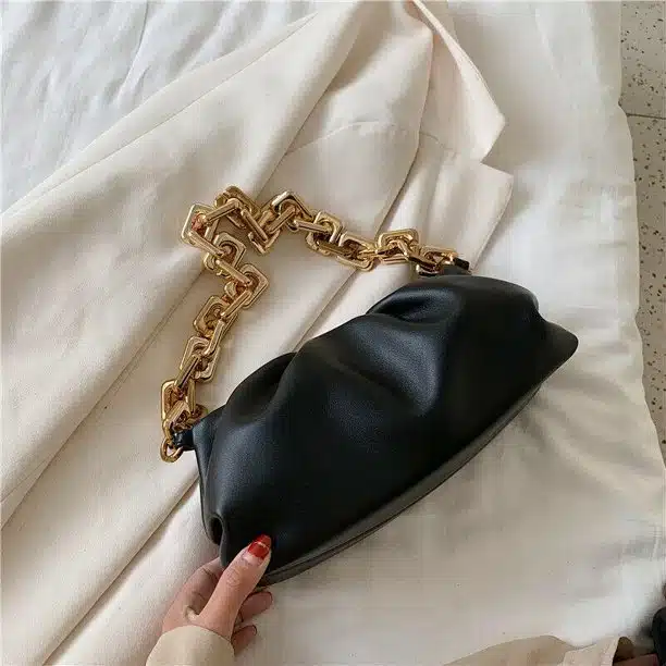 Black leather clutch with gold chain strap.