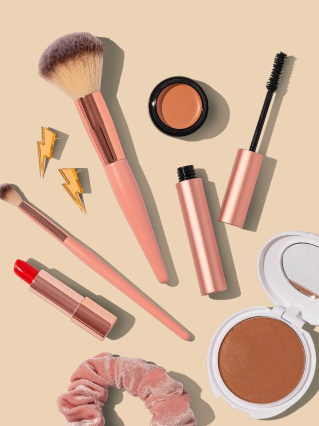 Makeup brushes and cosmetics on a beige background.